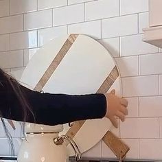 a woman standing in front of a white stove top oven holding a wooden spatula