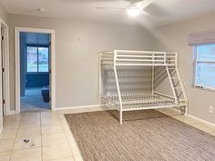 an empty room with a bunk bed in the corner and a rug on the floor