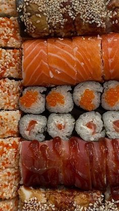 sushi platter with salmon, sesame seeds and other food items on it's sides