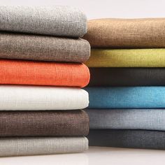 a stack of folded linens sitting on top of each other next to each other