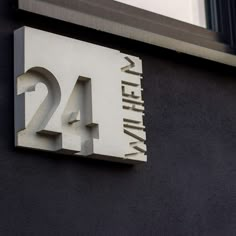 the number twenty four is mounted to the side of a building