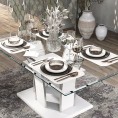 a glass table with plates and silverware on it in the middle of a room