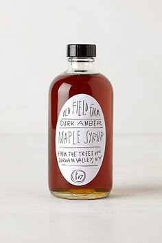 a bottle of maple syrup on a white surface