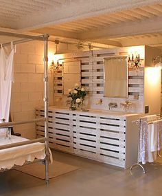 a bathroom with a bed, sink and mirror