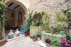 there are many potted plants and vases on the ground in front of an archway