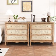 a white couch sitting next to a wooden dresser on top of a hard wood floor