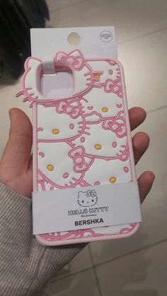 someone holding up a hello kitty phone case