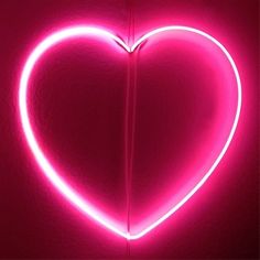 a heart shaped neon sign on a wall