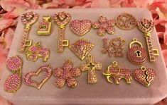 pink and gold charms are on a tray