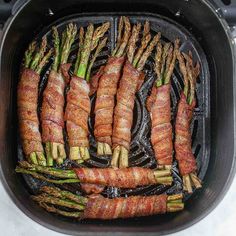 asparagus and bacon cooking in an air fryer