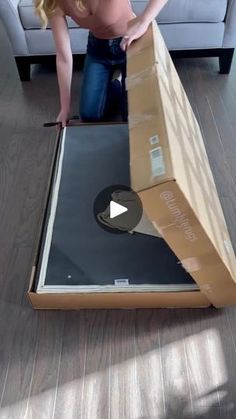 a woman is unpacking a box on the floor