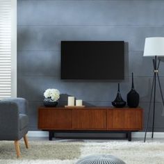 a living room scene with focus on the television and two gray chairs, one in front of the tv