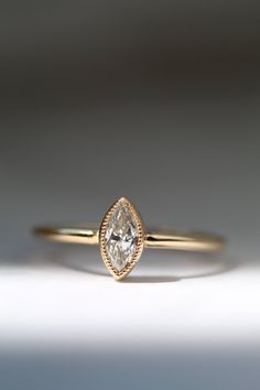 a yellow gold ring with a pear shaped diamond