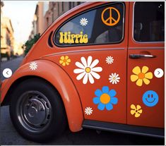 an orange vw bug with flowers and peace signs on it's back window