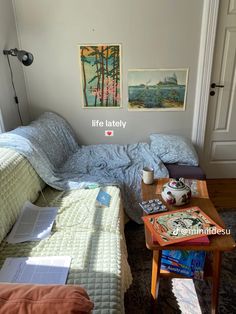 a small bedroom with a bed, coffee table and pictures on the wall above it