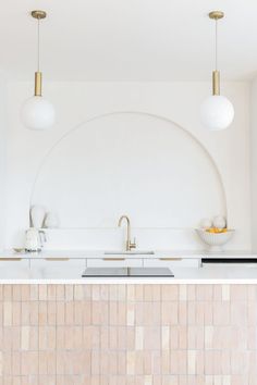 A white kitchen filled with natural light features a tiled island bench, brushed brass tapware and pendant lights. Timeless Kitchen Ideas, New Zealand House, Modern Mediterranean Home, Abi Interiors, Niche Wall, Modern Mediterranean Homes, Open Kitchen And Living Room, Mediterranean Interior, Mediterranean Kitchen