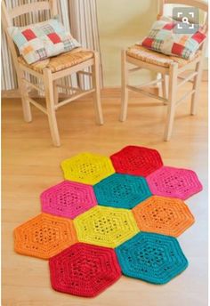 colorful crocheted hexagons on the floor in front of two chairs