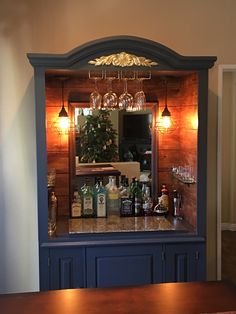 a bar with liquor bottles and glasses on it's counter top in front of a mirror