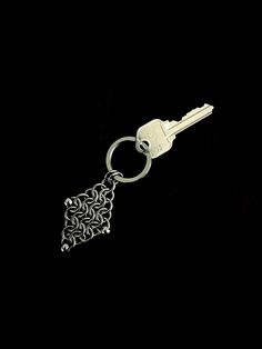 a keychain with a chain attached to it on a black background is shown