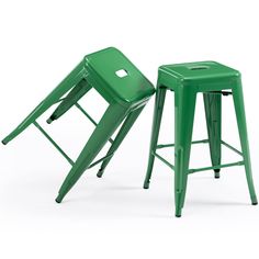 two green metal stools sitting next to each other on a white background, one with the seat up