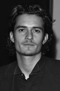 a black and white photo of a man with curly hair