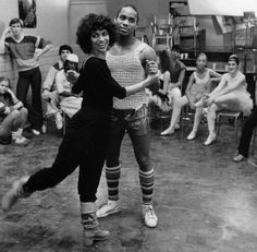 two people dancing in front of a group of dancers