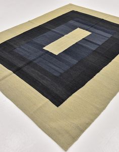 a black and beige area rug on a white surface with a square in the middle