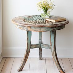 a small table with a book on it and flowers in a vase next to it