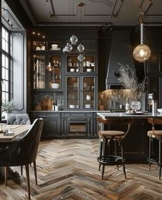 an elegant kitchen with black cabinets and wood flooring is pictured in this image, there are