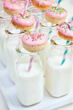 a table topped with glass jars filled with donuts and frosted sprinkles