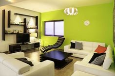 a living room with green walls and white furniture