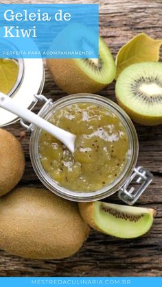 some kiwis are sitting on a wooden table and one is in a jar