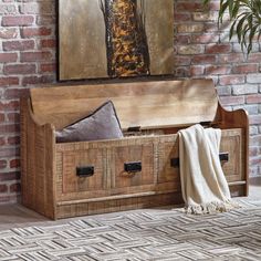 an old trunk is sitting on the floor in front of a brick wall with a painting above it