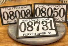 three signs that say home sweet home and the numbers on them are numbered in black