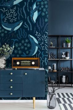 a living room with blue walls and an ocean themed wallpaper pattern on the wall