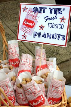 a basket filled with lots of food next to a sign that says get ye're fresh toasted peanuts