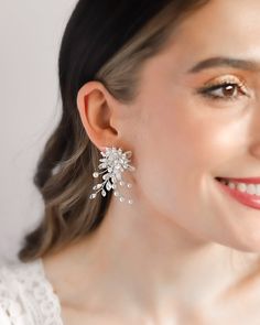 Perfect for adding a whimsical touch to any special occasion look, our Neve Floral Earrings bring a fresh take on timeless glamour. You'll have everyone commenting on these floral inspired statement earrings. Details: Hand wired with mix of light ivory pearls, rhinestones and tulle petals. Made with top grade rhinestones for ultimate sparkle. Specifications: 2" in length x 1.25" wide. Extremely lightweight and easily worn all day and evening. Tarnish Resistant: Earrings are tarnish resistant for Timeless Glamour, Light Ivory, Ivory Pearl, Floral Earrings, Statement Earrings, Metallic Silver, Silver Earrings, Special Occasion, Sparkle