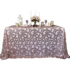 a table topped with candles and flowers on top of a white table cloth covered in lace