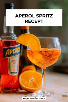 an aperol spritz recipe in a glass with orange wedges next to it