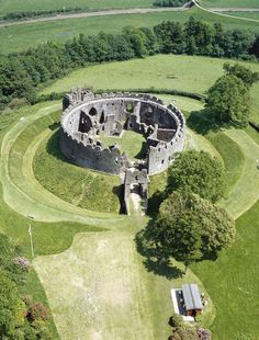 an aerial view of a castle surrounded by lush green fields