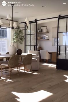 a dining room table and chairs in front of a large window