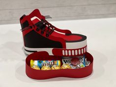 an open shoe box filled with candy and candies on top of a white table