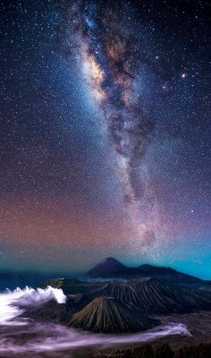 the night sky is filled with stars and clouds, as seen from above volcanos