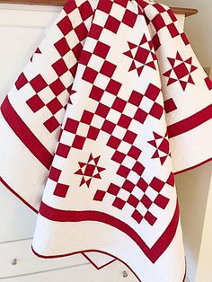 a red and white quilt hanging on the wall