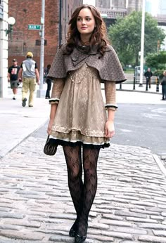 a woman is walking down the street wearing tights and stockings with her hands in her pockets