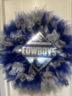 a blue and silver wreath with the word cowboys on it in front of a door