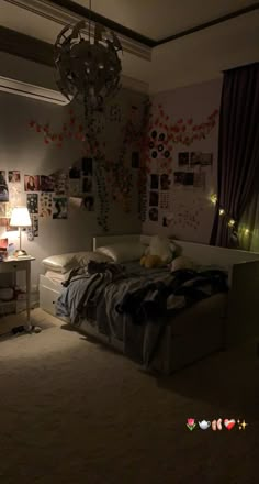 a bed sitting in a bedroom next to a lamp and pictures on the wall above it