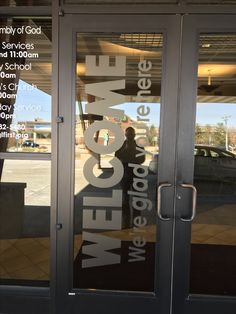 the front door of a building with glass and lettering on it that says welcome to me