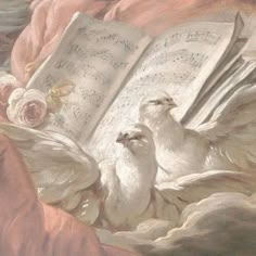 two white birds sitting on top of an open book with music sheets and roses in the background