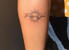 two hands touching each other with the sun shining behind them tattoo on arm and leg